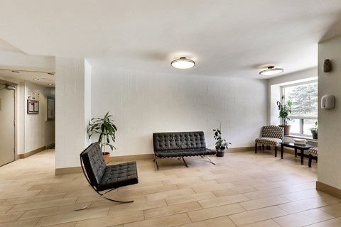 a living room with two black chairs and a table and a window