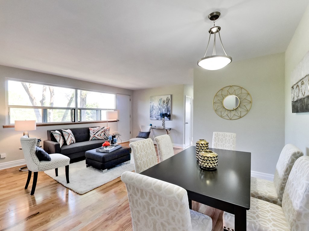 A black dining table with a bowl of fruit on it.