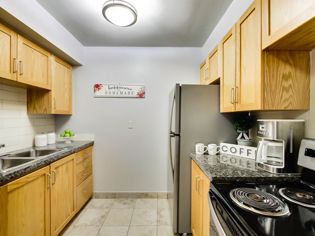 A kitchen with wooden cabinets and a sign that says
