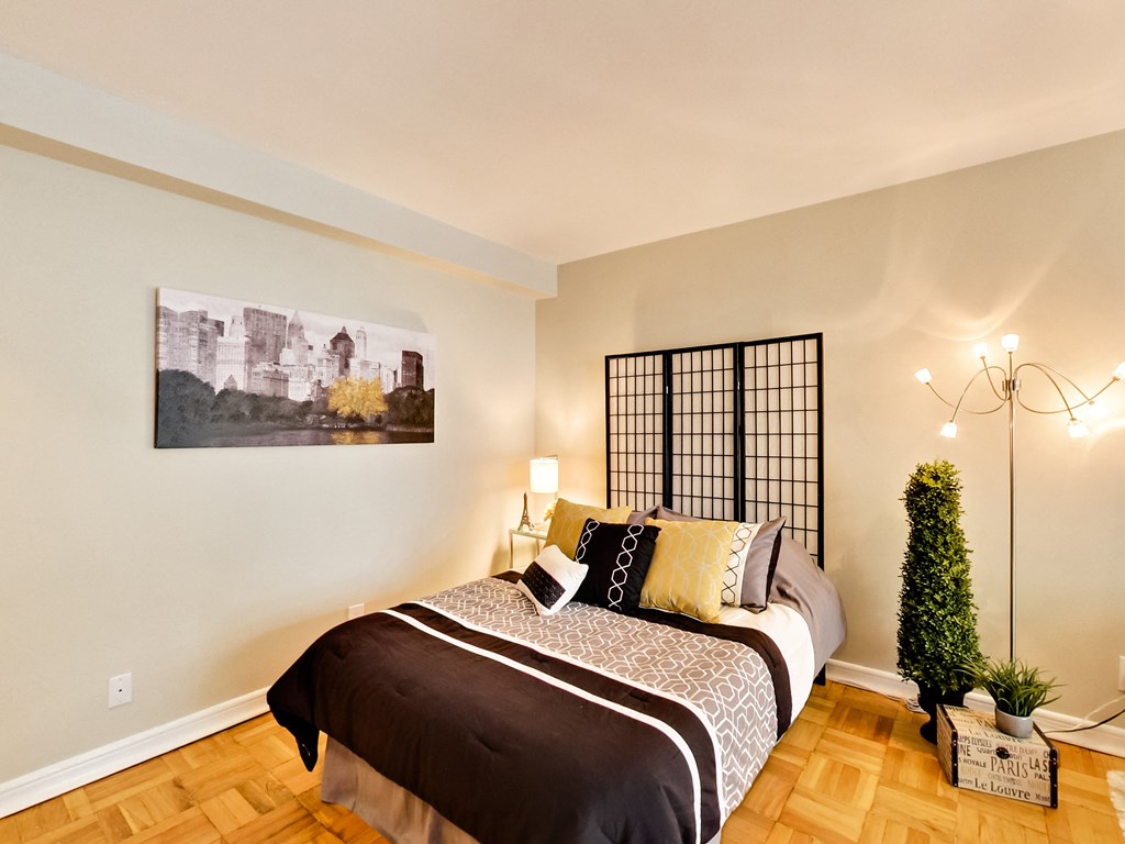 a bedroom with a bed and a painting on the wall