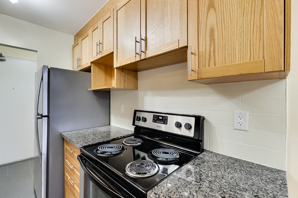 A kitchen with a stove top oven and a refrigerator.