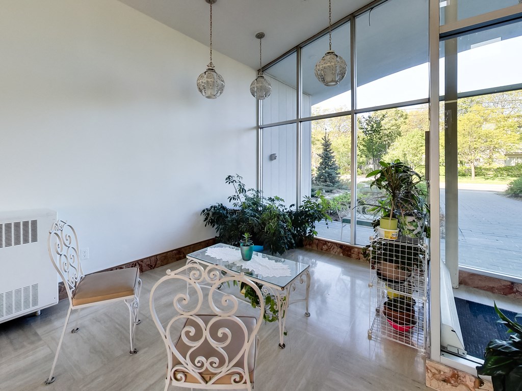 a living room with a table and chairs and a large window