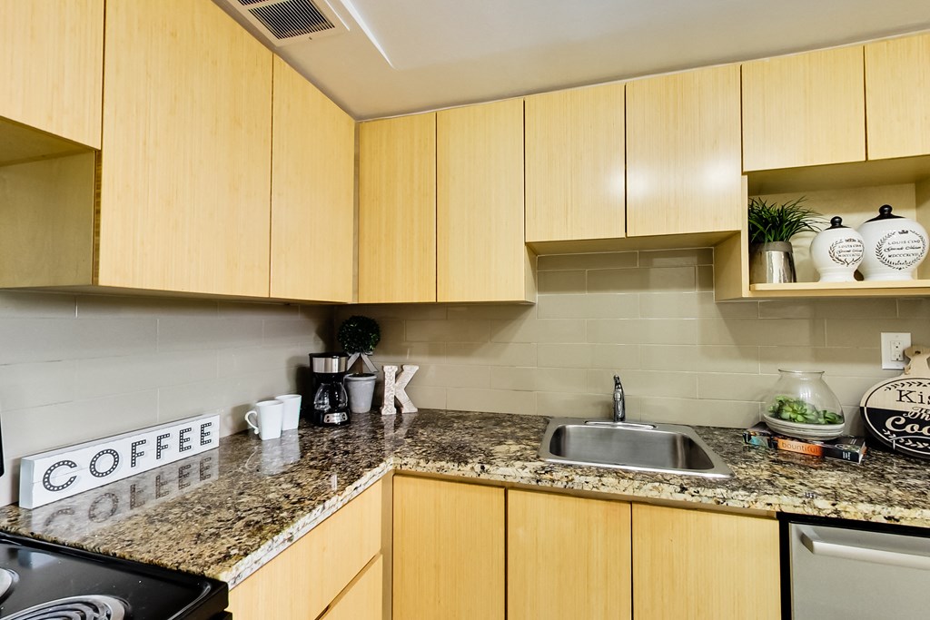 A kitchen with wooden cabinets and a granite countertop.