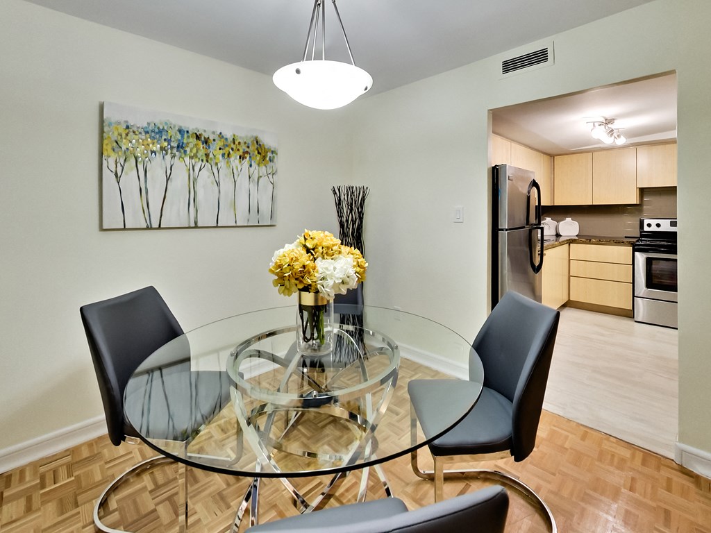 A modern dining room with a glass table and chairs.
