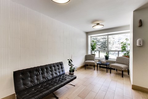 a living room with black leather furniture and a large window
