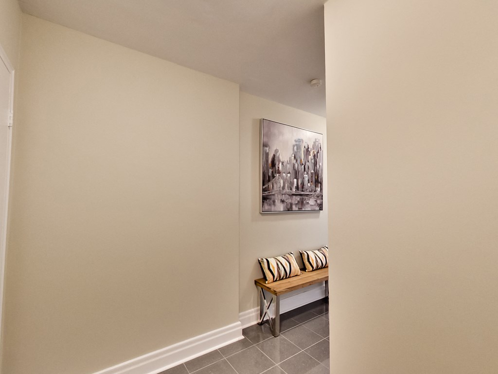 a hallway with a bench and a painting on the wall