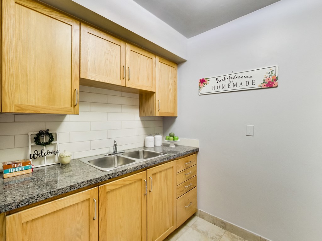 A kitchen with wooden cabinets and a sign that says