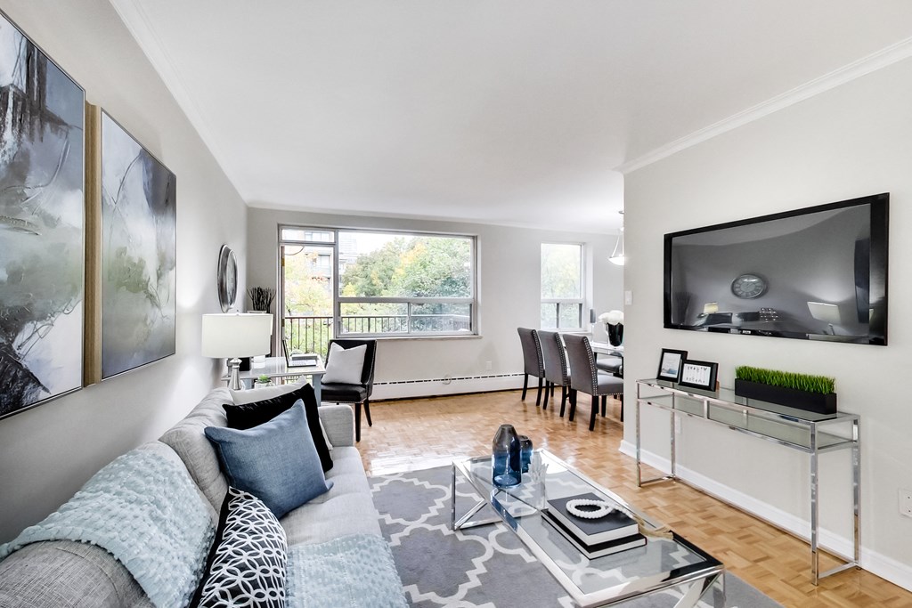 a living room with a couch and a glass coffee table and a television