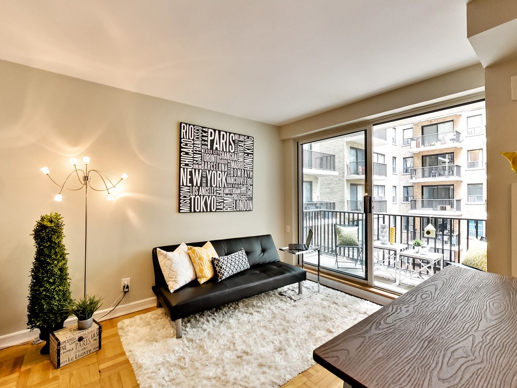 a living room with a couch and a table and a balcony