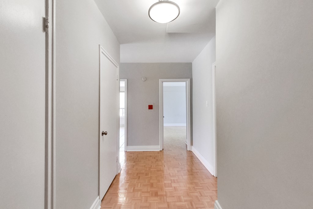 an empty hallway with white walls and a wood floor