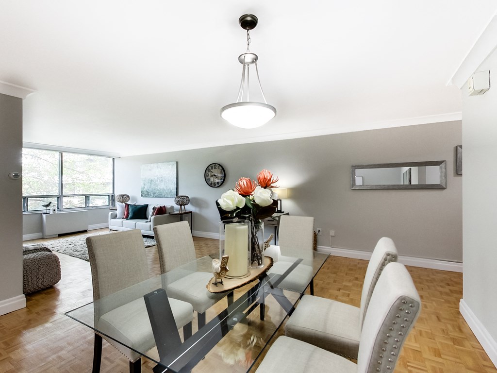 A modern dining room with a glass table and chairs.