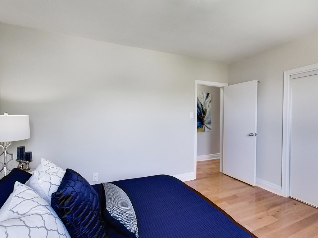 A bedroom with a bed and a lamp.