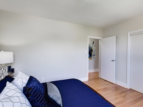 A bedroom with a bed and a lamp.