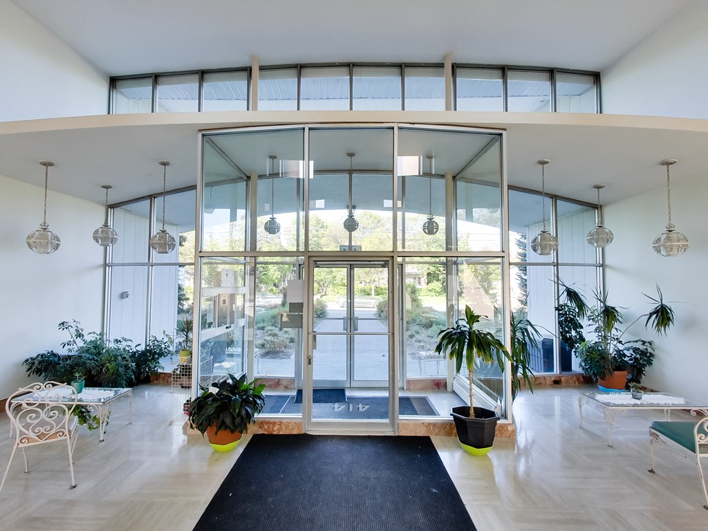 a living room with glass doors and potted plants