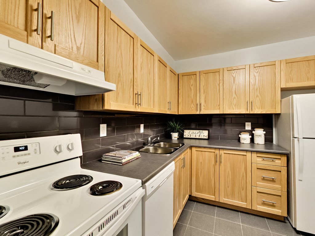 A kitchen with wooden cabinets and a white stove.