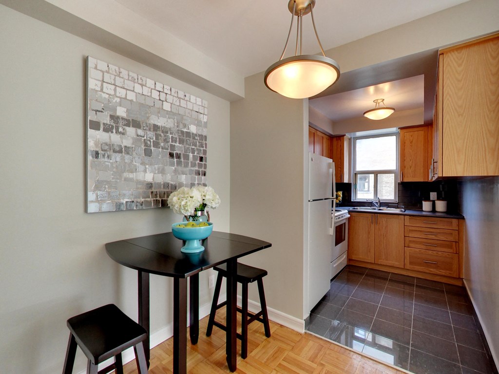 a kitchen with a black table and stools in front of a window