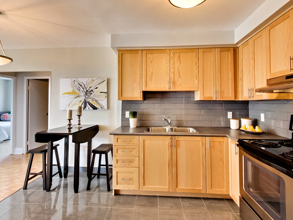 a kitchen with wooden cabinets and a table with stools
