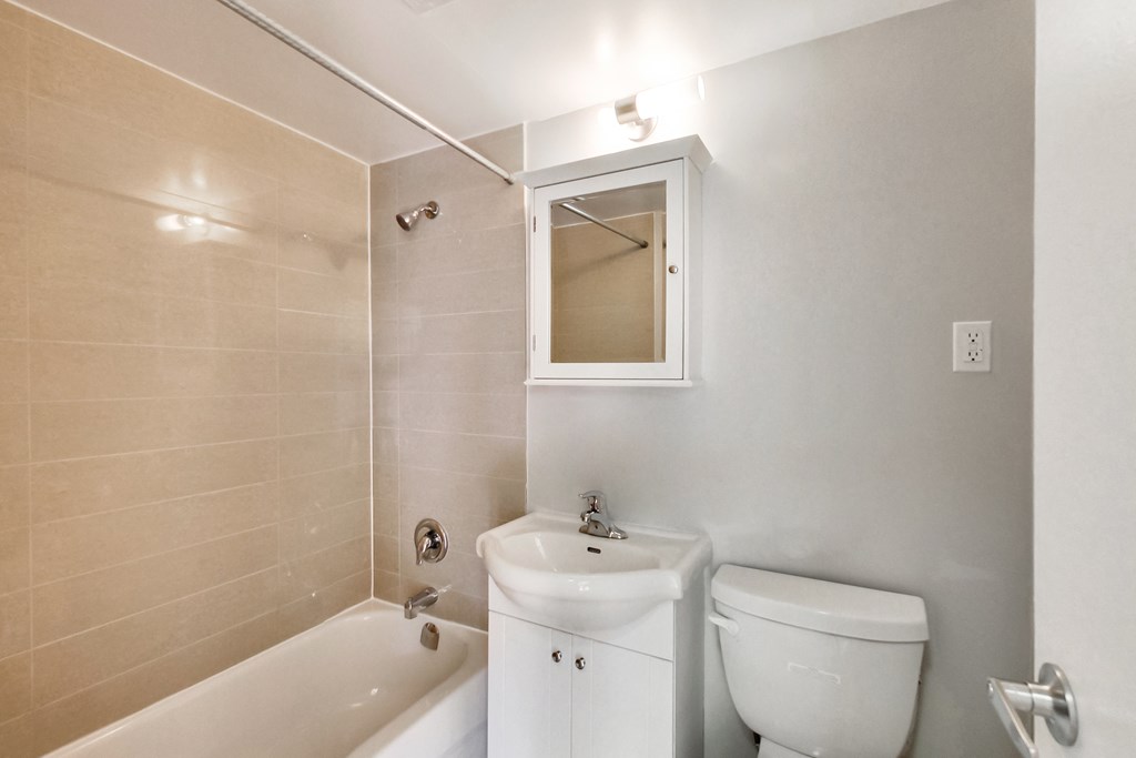 a bathroom with a toilet and a tub and a sink