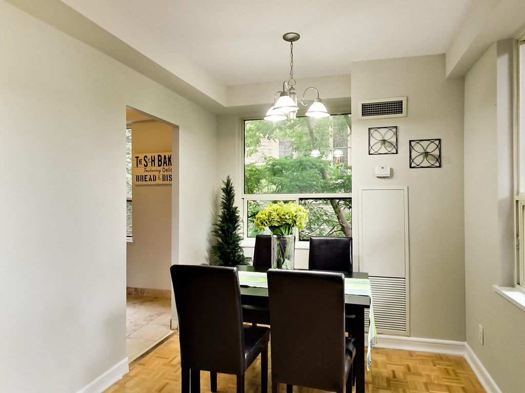 a dining room with a table and chairs and a window