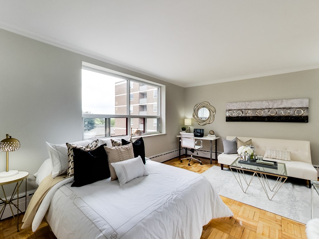 a bedroom with a bed and a couch and a window