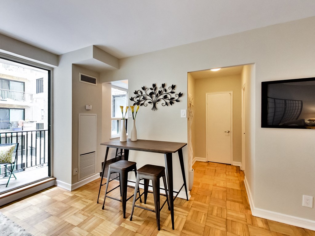 a dining room with a table and stools and a large window