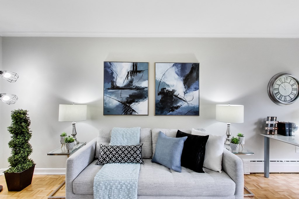 a living room with a couch and two paintings on the wall