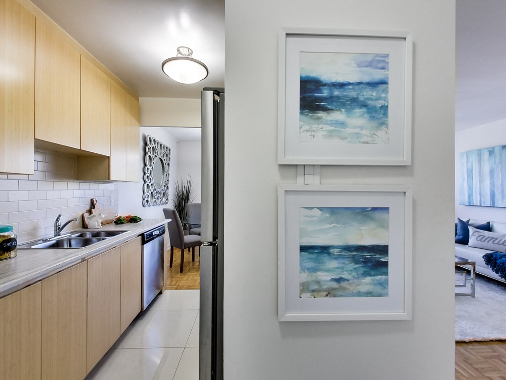 a kitchen and living room with two pictures on the wall