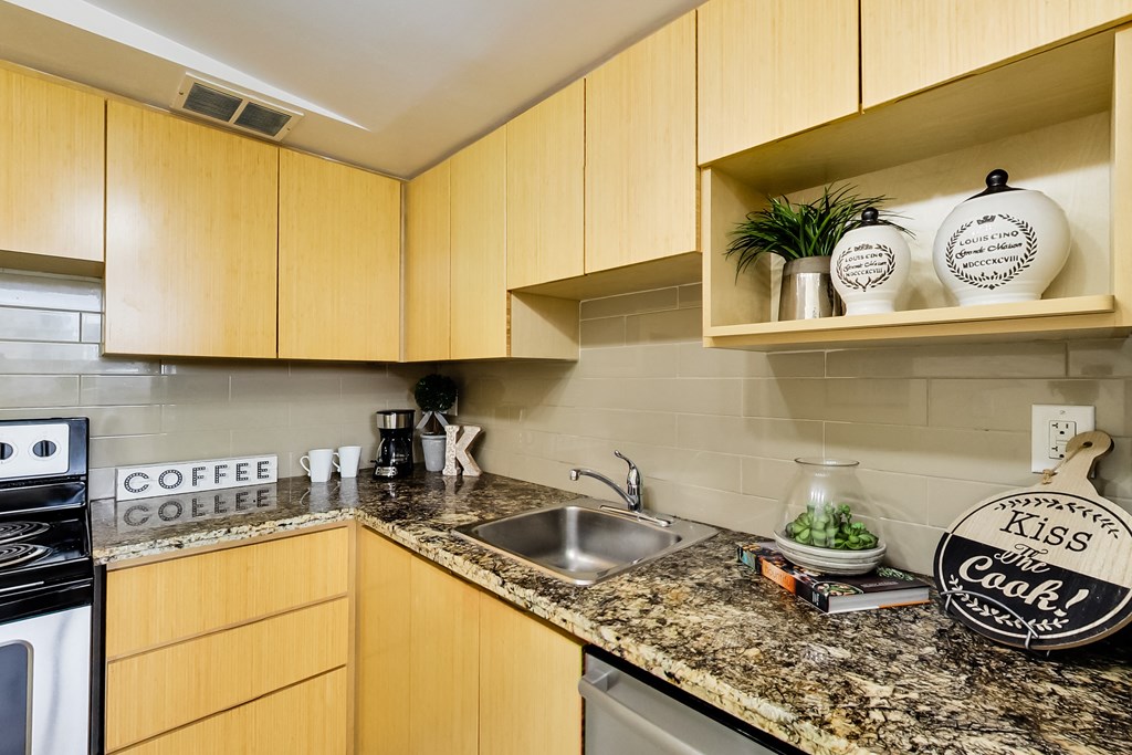 A kitchen with wooden cabinets and a granite countertop.