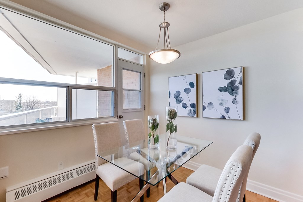 A dining room with a glass table and chairs.