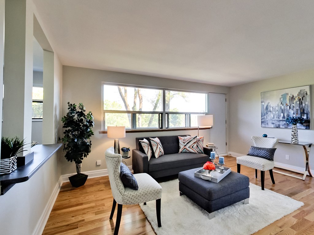 A living room with a couch, chair, and a tree.