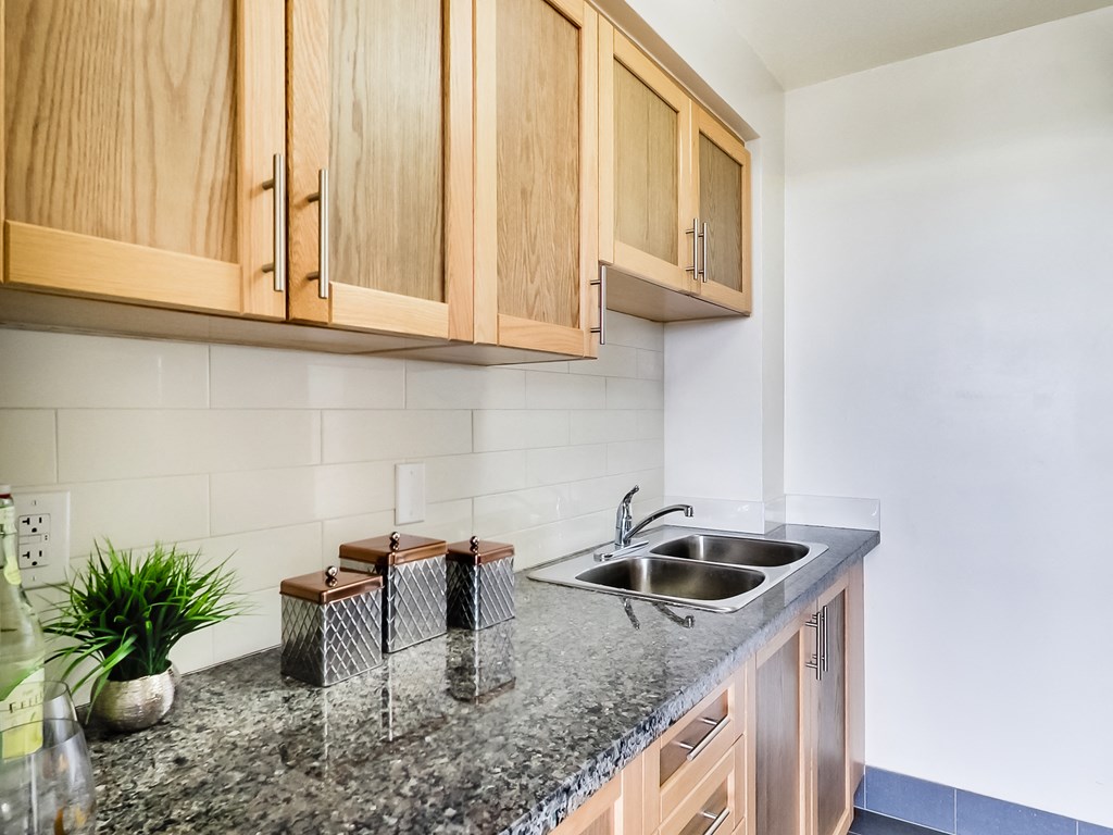 A kitchen with wooden cabinets and a granite countertop.
