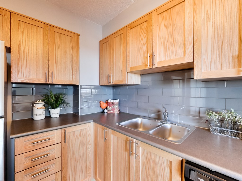 a kitchen with wooden cabinets and a stainless steel sink