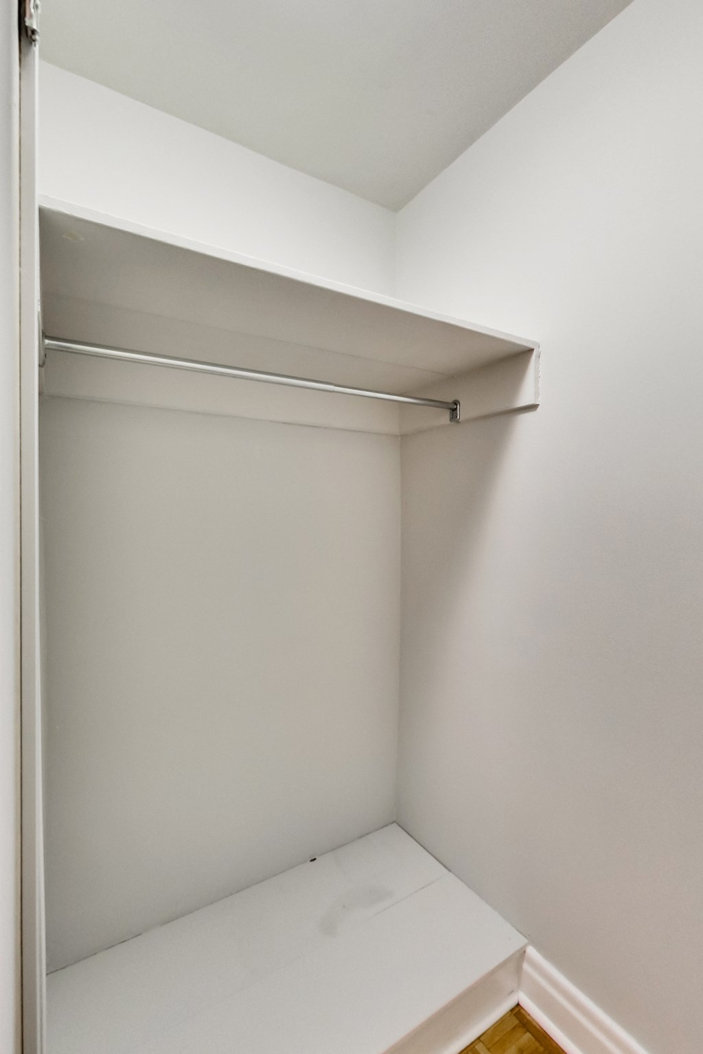 an empty closet with a white shelf in it