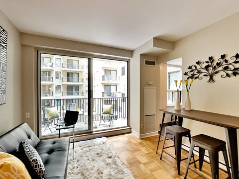 A living room with a black couch and a wooden table.