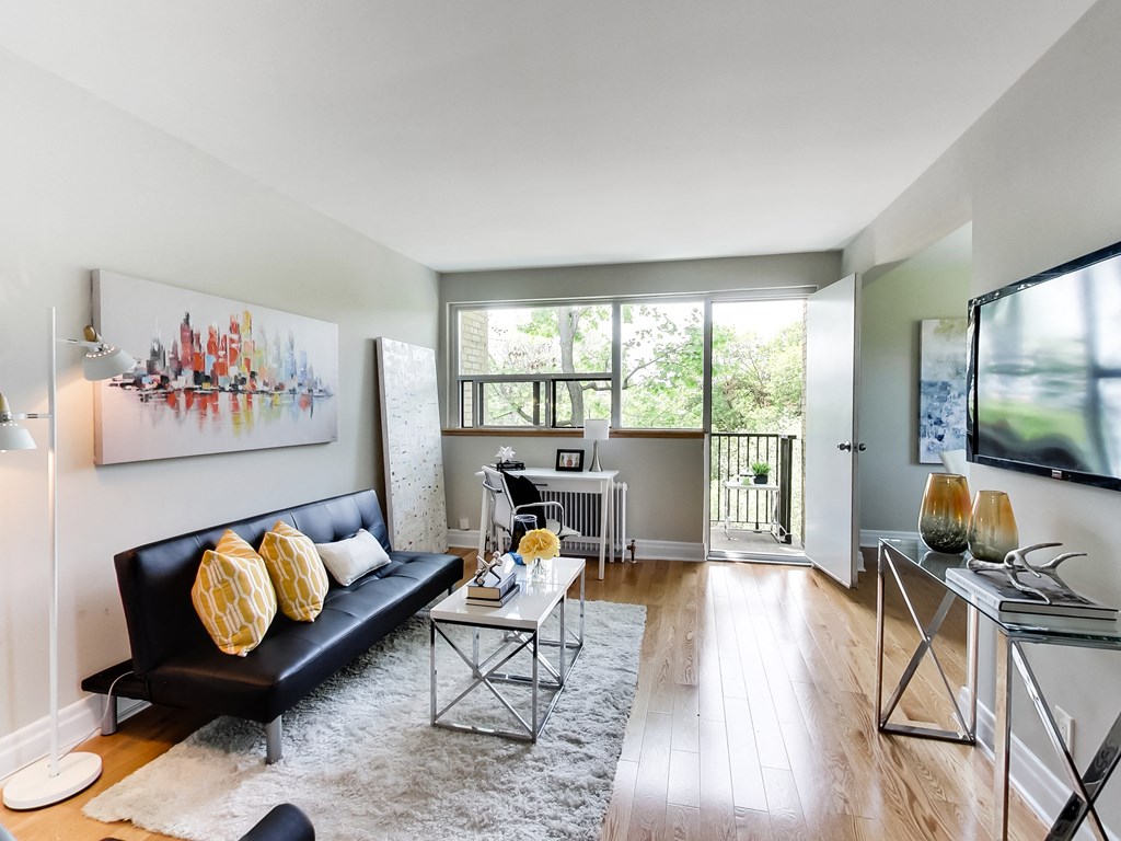 A living room with a black couch and a white coffee table.