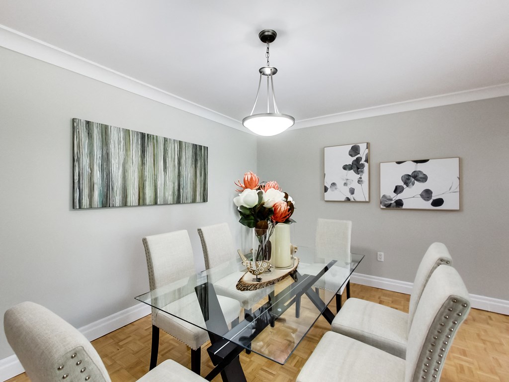 A dining room with a glass table and chairs.