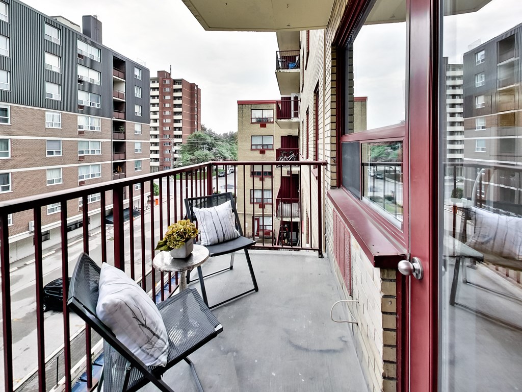 a small balcony with two chairs and a table on it