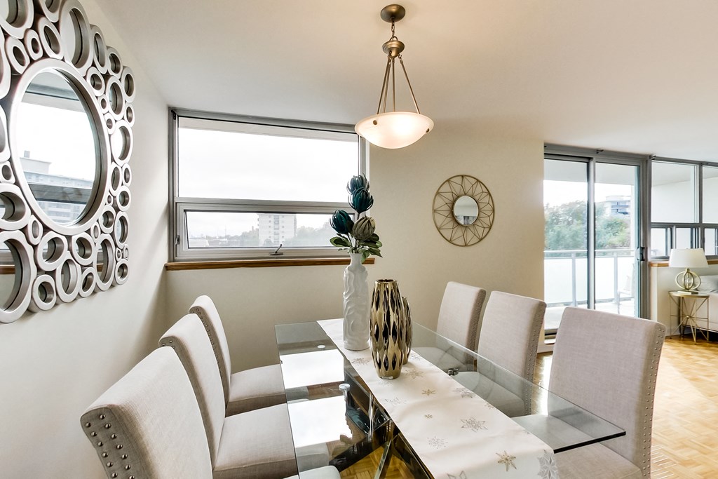 A modern dining room with a glass table and chairs.