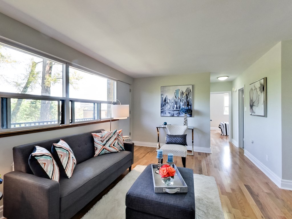 A living room with a grey couch and a coffee table in front of it.