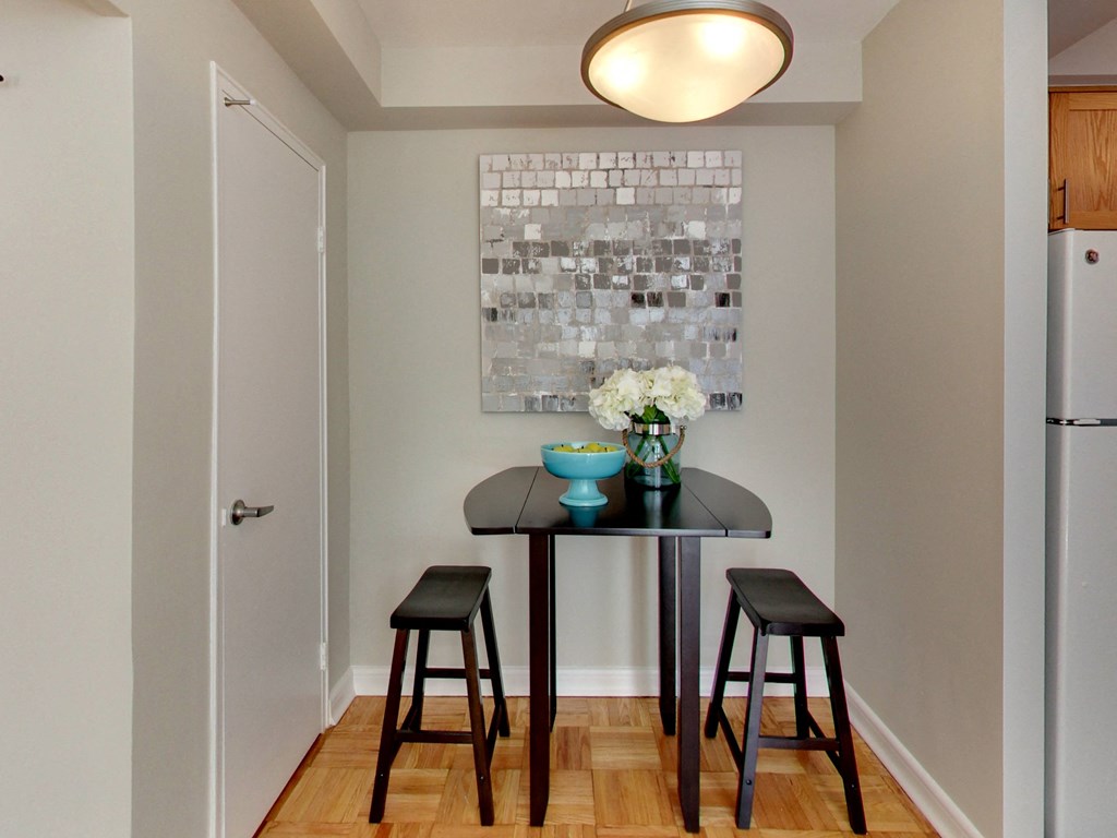 a small kitchen with a table and stools and a painting on the wall