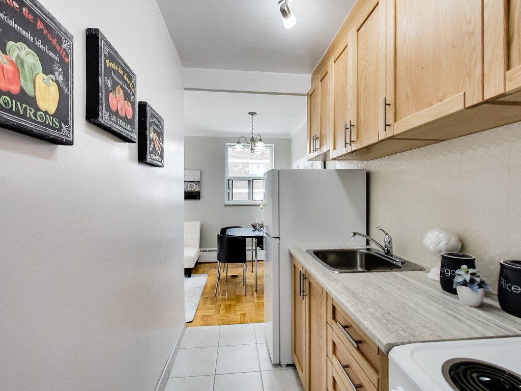 a kitchen with wooden cabinets and a sink and a refrigerator