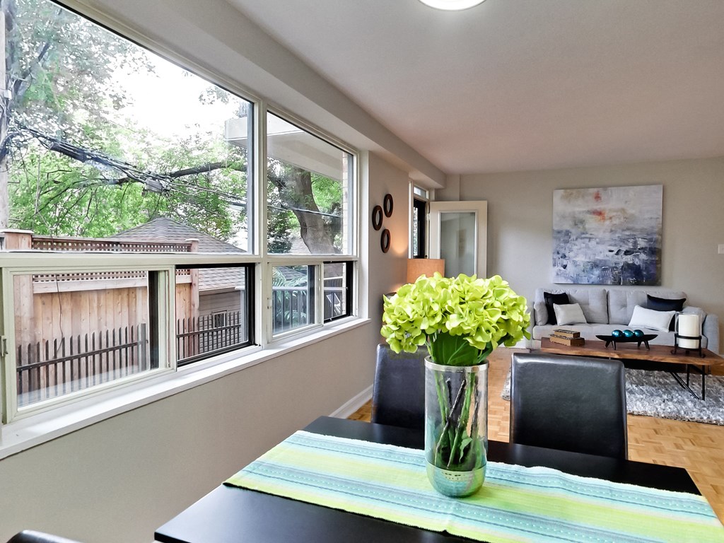 a dining room with a table and a vase of flowers