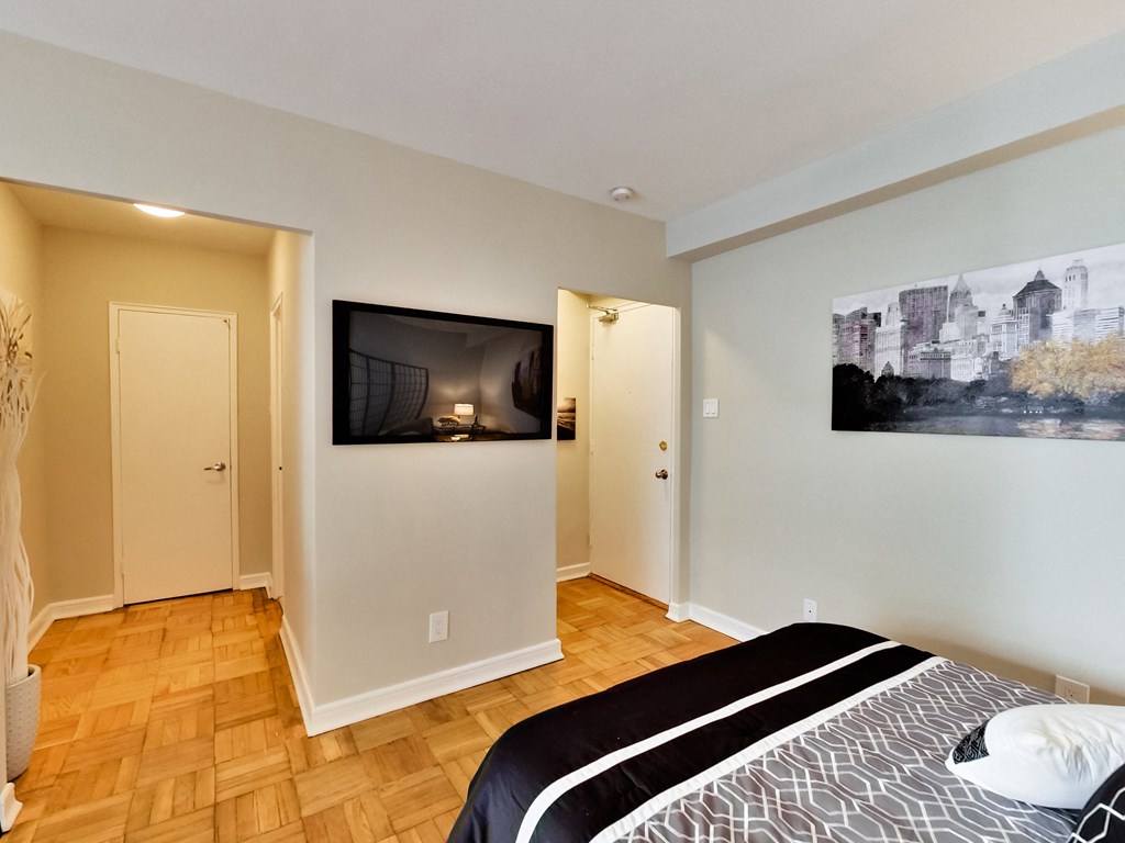 a bedroom with a tv on the wall and a bed