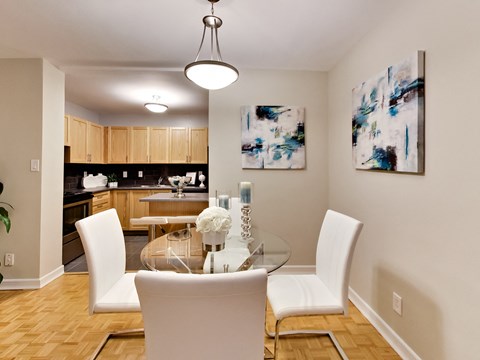 a dining room with white chairs and a glass table