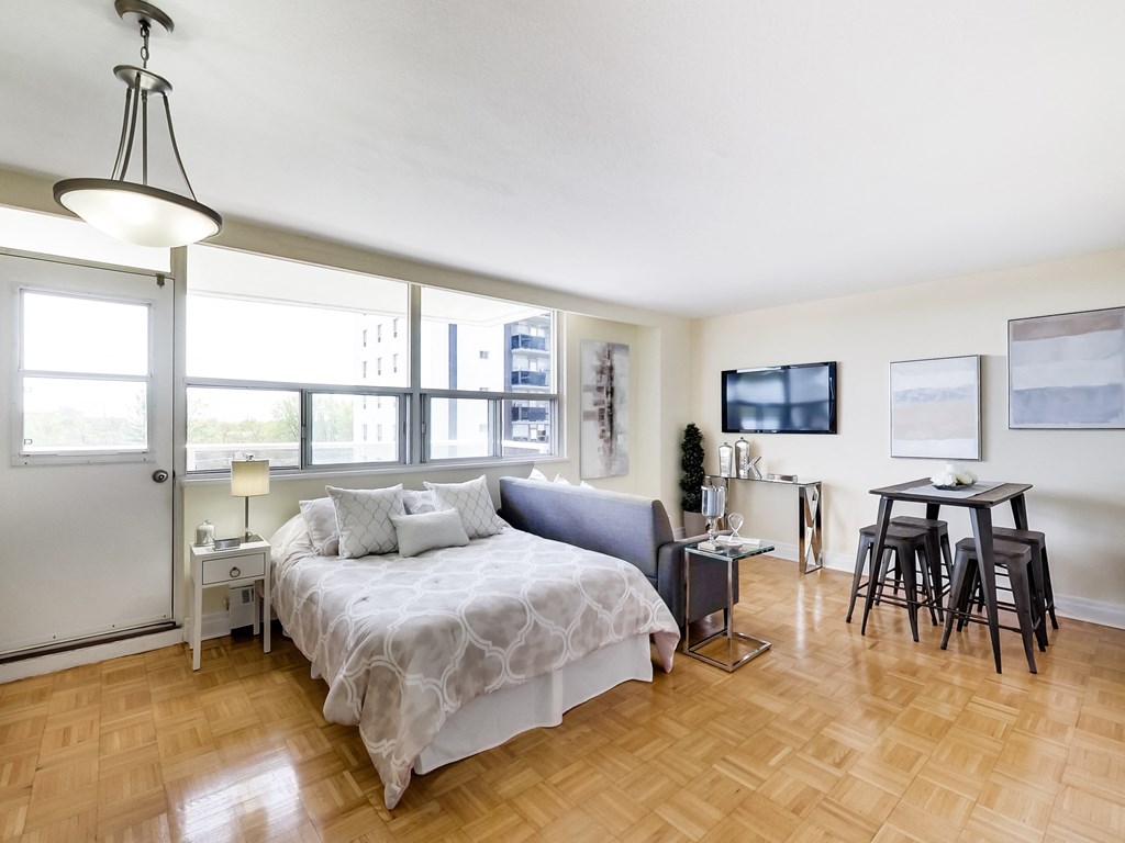 A bedroom with a bed, a chair, and a table.