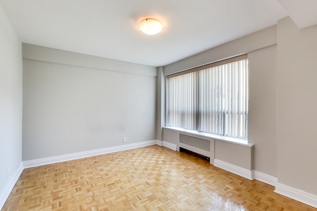 an empty living room with wood flooring and a large window