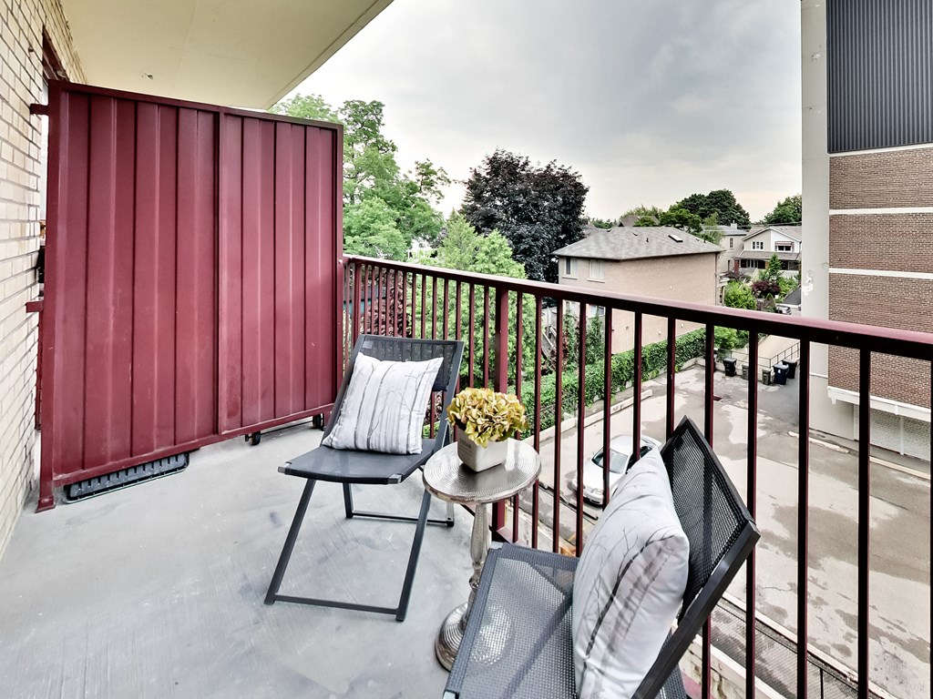 a balcony with two chairs and a table