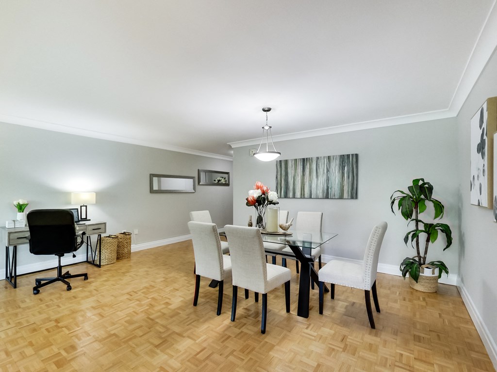 A dining room with a glass table and chairs.