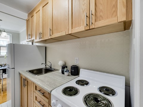 A kitchen with a white stove and wooden cabinets.