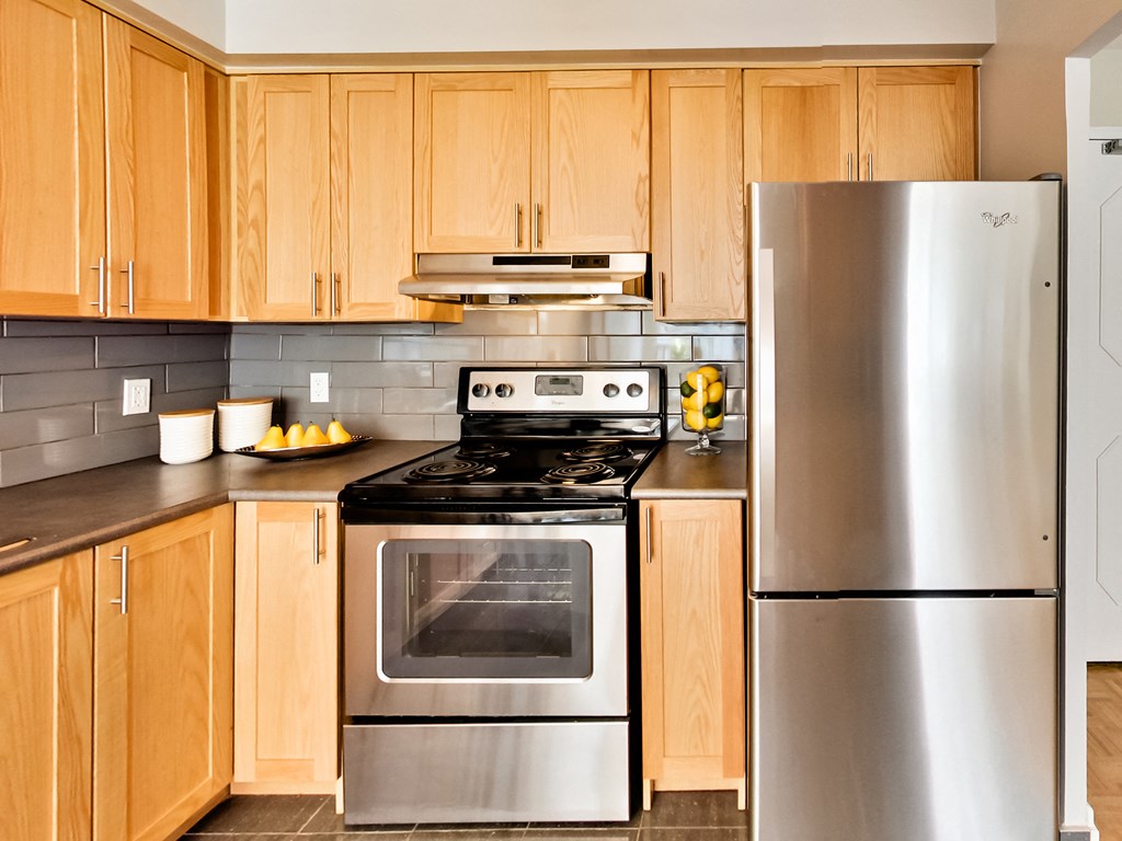 a kitchen with stainless steel appliances and wooden cabinets